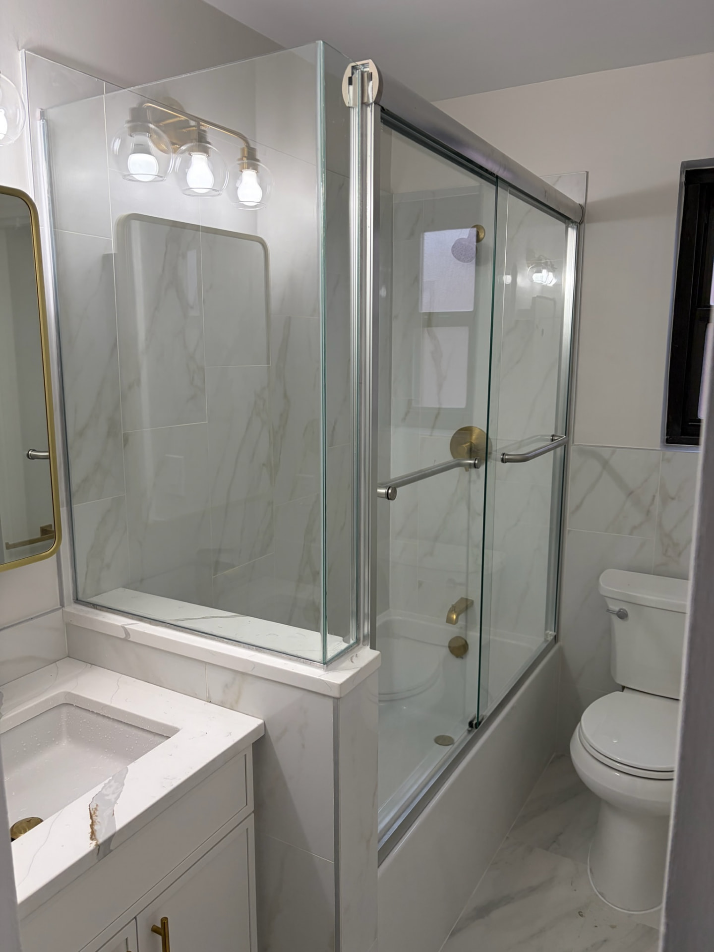 Glass shower enclosure in a tiled bathroom.